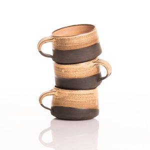 כוסות קרמיקה בעבודת יד בצבעים דו-גוניים: חום בהיר בחלק העליון ושחור כהה בחלק התחתון.