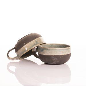 כוס קרמיקה דו-גונית בעבודת יד: חלק תחתון שחור כהה וחלק עליון בגלזורה תכלת-בהירה